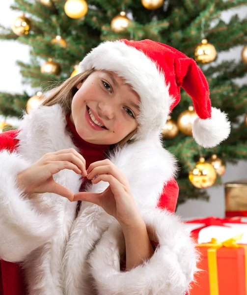 Jovencita feliz sonriendo cerca del árbol de Navidad . — Foto de Stock