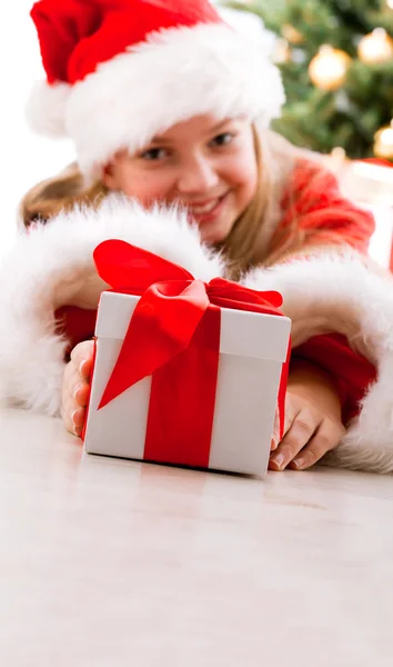 Gelukkig jong meisje lachend met de doos van de gift in de buurt van de kerstboom. — Stockfoto