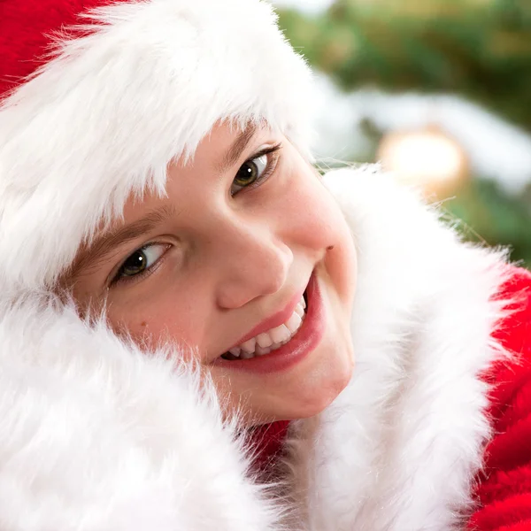 Happy young girl smiling near the Christmas tree. — Stock Photo, Image