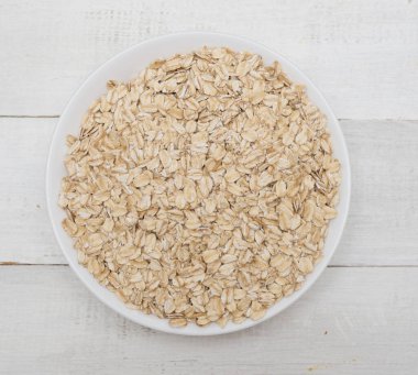 Tahta arka planda bir kasede yulaf lapası manzarası