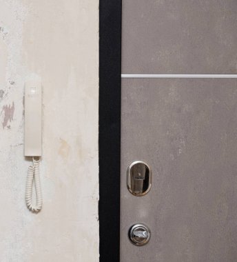 Kapıya yakın bir duvarda dahili telefon var.