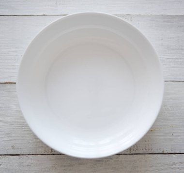 Tahta masadaki beyaz boş tabağın üst görüntüsü