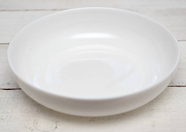 Tahta bir masada beyaz boş bir tabak.