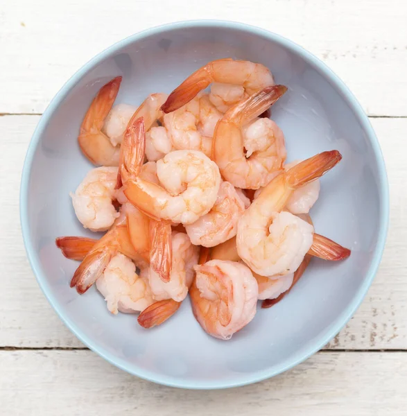 Tahta masadaki marinalı karideslerin en üst görüntüsü.