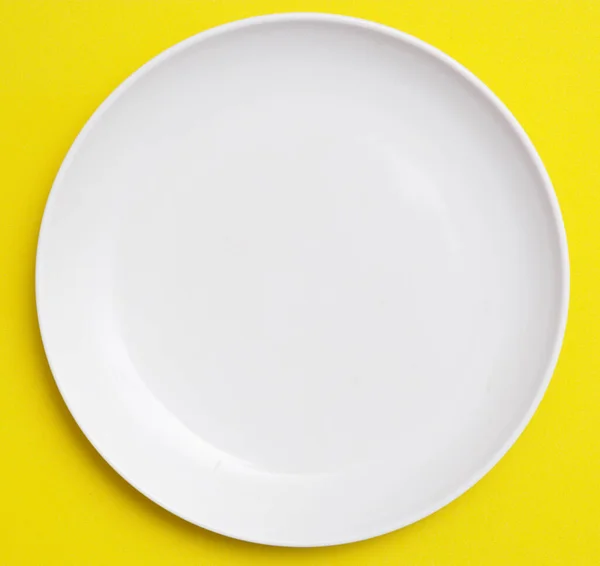 White Plate Yellow Background — Stockfoto