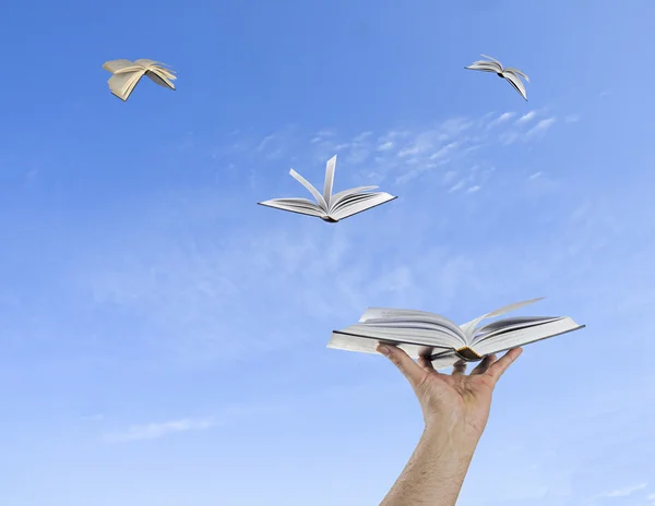 Libros volando de las manos — Foto de Stock