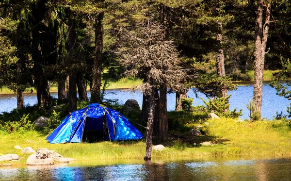 Голубая палатка возле озера — стоковое фото
