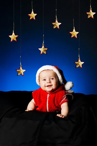 Weinig schattige baby met kerstmuts en sterrenhemel — Stockfoto