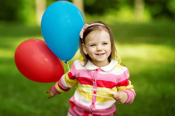 Liten flicka leker med ballonger — Stockfoto