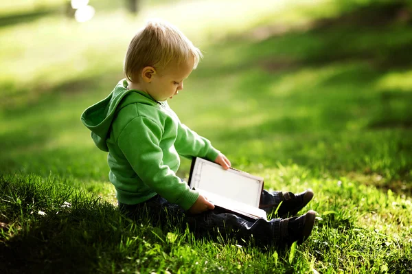 Liten pojke läser bok — Stockfoto