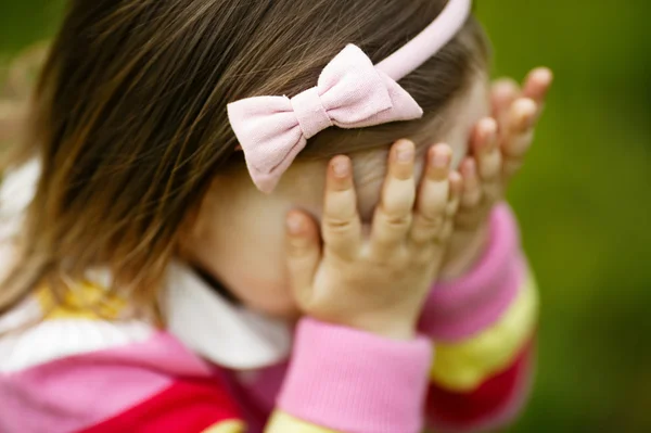 Baby is playing hide-and-seek hiding face — Stock Photo, Image