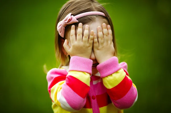 Dítě hraje na schovávanou skrývá tvář — Stock fotografie