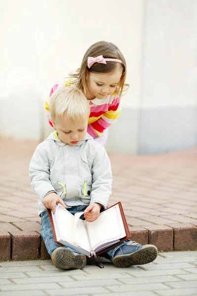 Lindo chico y chica leyendo un libro Fotos de stock libres de derechos