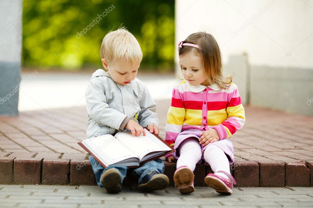 cute boy and girl reading a book