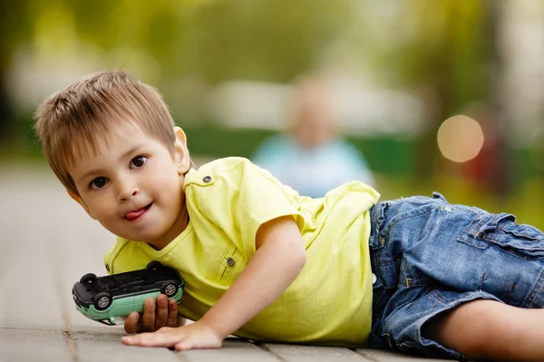 Menino brinca com carro de brinquedo — Fotografia de Stock