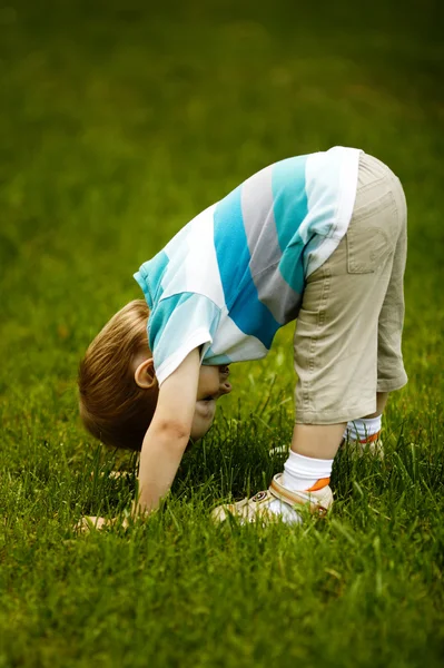 The little boy looks upside down — Stock Photo, Image