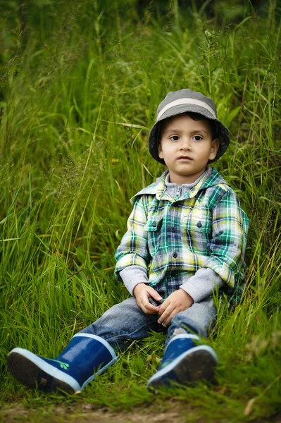 小男孩坐在草 — 图库照片