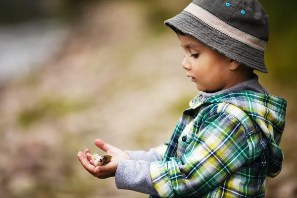 Pequeño niño sostiene un poco de pescado —  Fotos de Stock