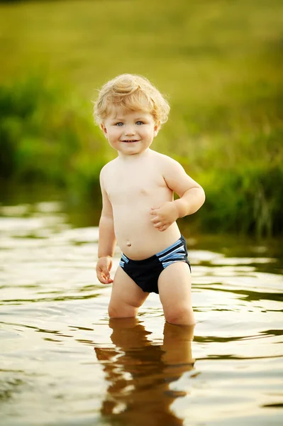 Menino engraçado brincando na água — Fotografia de Stock