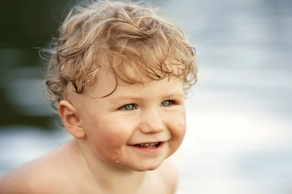 Menino engraçado brincando na água — Fotografia de Stock