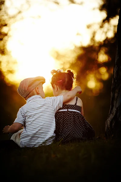 Garçon et fille au coucher du soleil — Photo