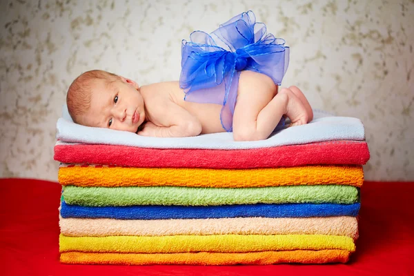 Cute newborn baby lying on colorful towels — Stock Photo, Image