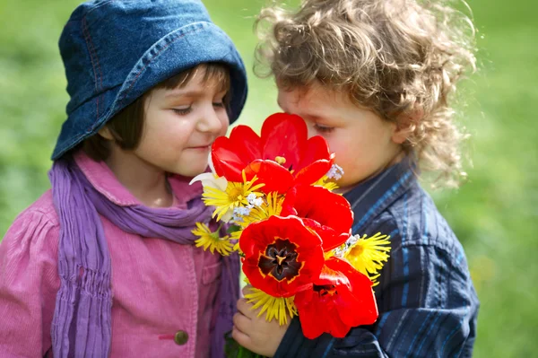 Αγόρι και κορίτσι με μπουκέτο λουλούδια — Φωτογραφία Αρχείου