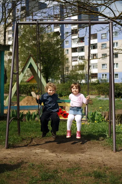 Chlapec a dívka na houpačce — Stock fotografie