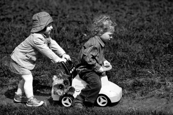 Niño y niña en el parque con coche de juguete — Foto de Stock