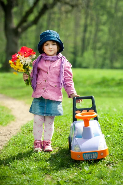 Vacker liten flicka med bil i park — Stockfoto