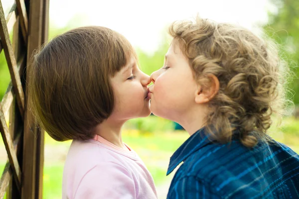 Liten pojke kyssar flicka — Stockfoto