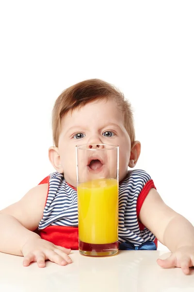 Weinig schattige baby met glas sap geïsoleerd — Stockfoto