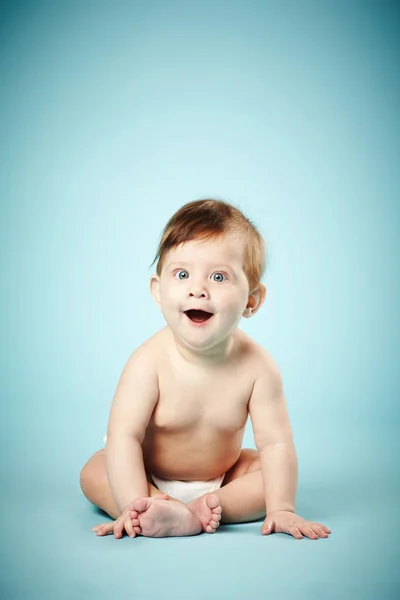 Roztomilé šťastné dítě na modrém pozadí — Stock fotografie