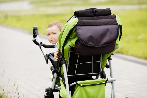 Little funny girl with baby carriage — Stock Photo, Image