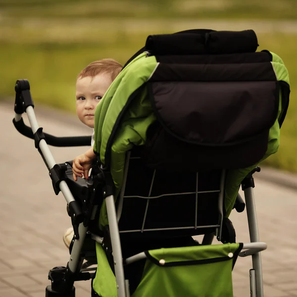 Little funny girl with baby carriage — Stock Photo, Image