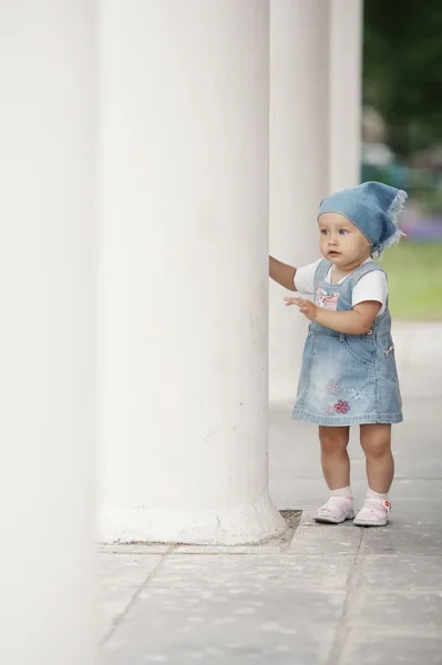 Маленькая девочка прячется в колоннах — стоковое фото