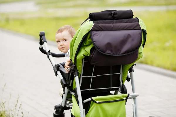 Little funny girl with baby carriage Royalty Free Stock Photos