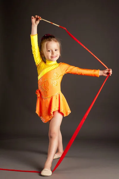 Holčička dělá rytmickou gymnastiku s mašlí — Stock fotografie