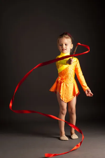 Kleines Mädchen macht rhythmische Gymnastik mit Band — Stockfoto