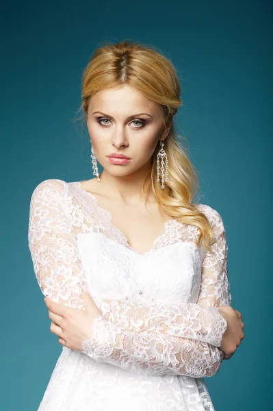 Beautiful girl in wedding dress on blue background — Stock Photo, Image