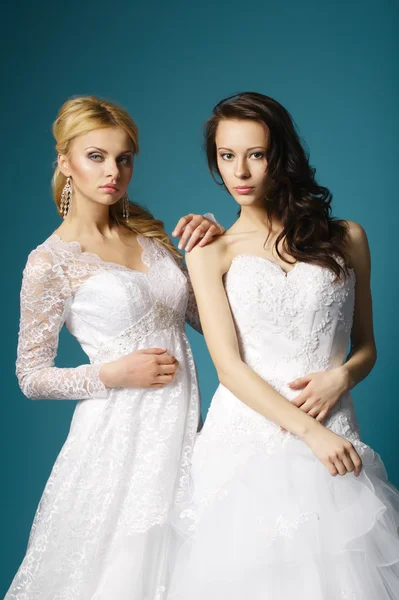 Blonde and brunette bride on blue background — Stock Photo, Image