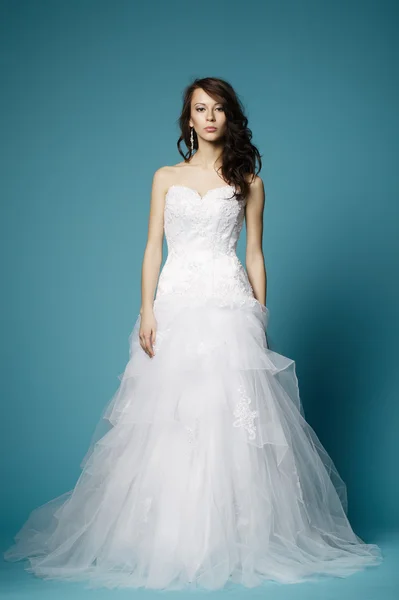 Beautiful girl in wedding dress on blue background — Stock Photo, Image