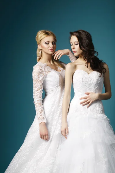 Blonde and brunette bride on blue background — Stock Photo, Image