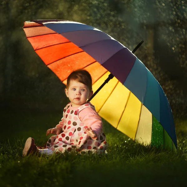 Parkta bir gökkuşağı şemsiye ile küçük kız — Stok fotoğraf