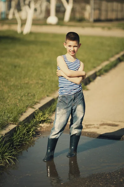 Little boy standing in puddle — Stock Photo, Image