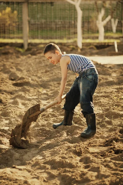 Menino trabalhando com pá no jardim — Fotografia de Stock