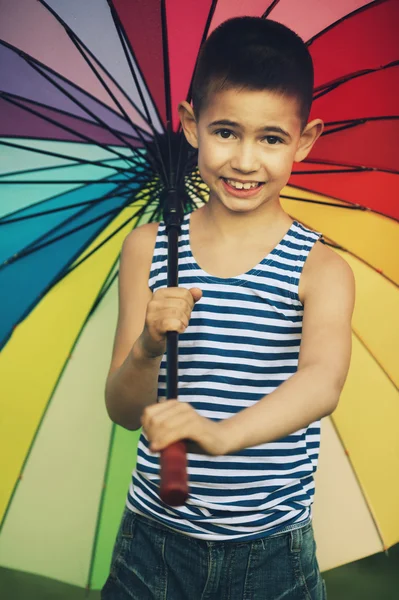 Meisje met een regenboog paraplu in park — Stockfoto