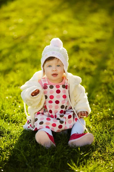 Дитина сидить на траві в саду — стокове фото