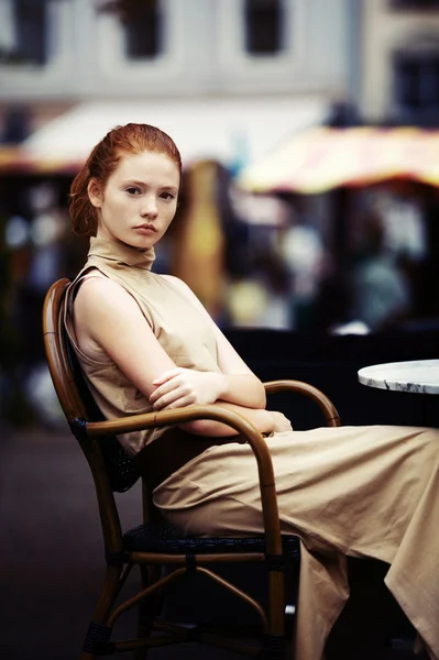 Beautiful girl waiting at a table in a cafe — Stock Photo, Image