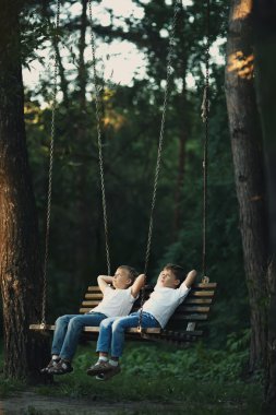 küçük çocukları salıncakta sürme